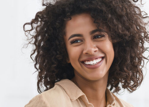Smiling woman with dark, curly hair