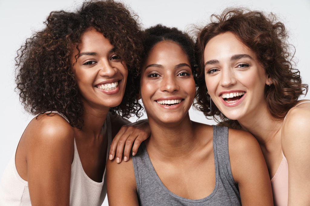 Three smiling women with great skin